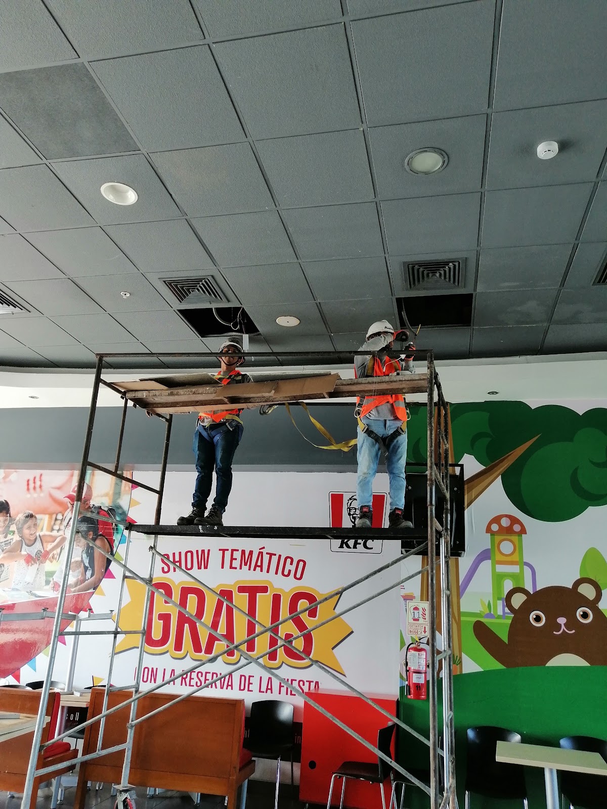 Personal ACERCON trabajando en el falso cielo de una tienda KFC
